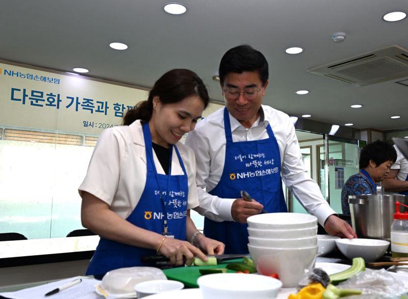 NH농협손해보험은 지난 19일, 서울 종로구에 위치한 한국전통음식연구소에서 다문화 가족 이주여성들과 함께 여름 보양식 만들기 체험을 하였다고 22일 밝혔다. 장경민 농협손해보험 부사장(사진 오른쪽)이 여름 보양식 만들기 체험을 하고 있다. 사진=NH농협손해보험 제공