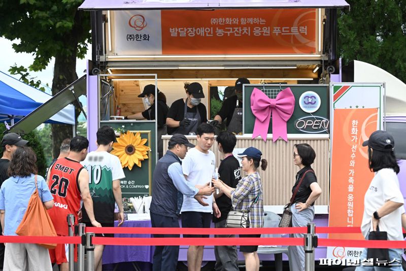 지난 20일 서울시 노원구 한국과학기술대학교에서 진행된 '제22회 서울특별시 발달장애인 농구잔치' 행사장에 마련된 (주)한화 컵빙수 푸드트럭에서 선수 등 관계자들이 음료를 받고 있다. 한화 제공