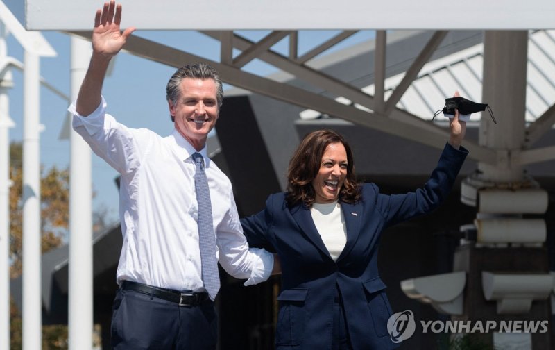 뉴섬 캘리포니아 주지사와 해리스 미국 부통령 (FILES) US Vice President Kamala Harris (R) waves alongside California Governor Gavin Newsom during a campaign event against his recall election at the IBEW-NECA Joint Apprenticeship Training Center in San Leandro, California, September 8, 2021. Joe Biden on July 21, 2024 dr