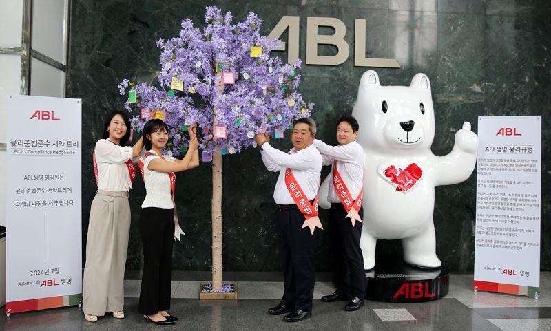 22일 서울 여의도 본사에서 시예저치앙 ABL생명 사장(오른쪽에서 두번째)과 임직원들이 준법의지 메시지를 서약 트리에 매달고 기념촬영을 하고 있다. ABL생명제공