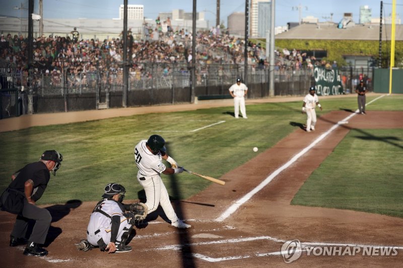 마이너리그 경기 모습 FILE - Oakland Ballers' Dondrei Hubbard (20) hits a two-run home run against the Yolo High Wheelers during the first inning of a baseball game at Raimondi Park in Oakland, Calif., June 4, 2024. Baseball fans and others interested in supporting the new Ballers independent minor league tea