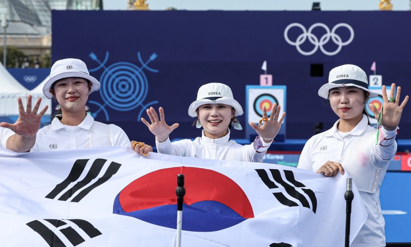 대한민국 양궁대표팀 임시현, 남수현, 전훈영이 29일(한국시간) 프랑스 파리 레쟁발리드 특설 사로에서 열린 2024 파리올림픽 양궁 여자 단체전 중국과의 결승전에서 금메달을 획득한 후 태극기를 들어보이고 있다. / 사진 = 뉴스1