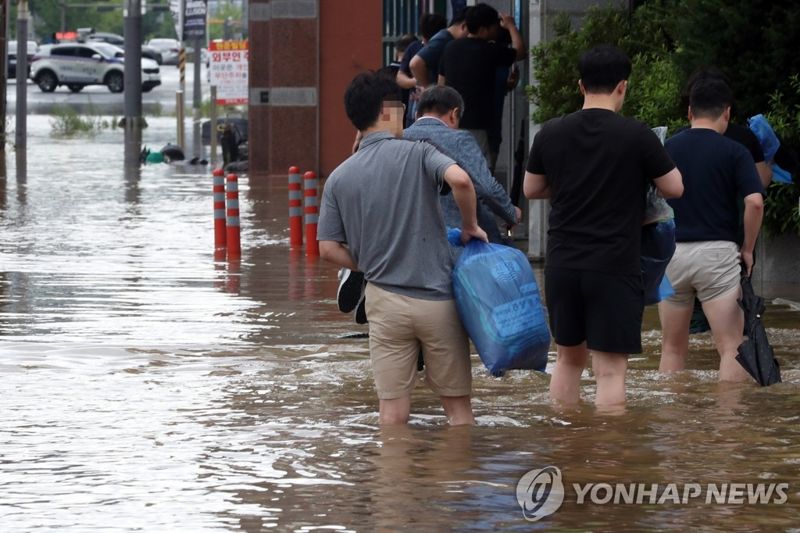 지난해 7월 24일 오전 전남 목포시 석현동 시가지에서 금융기관 직원들이 폭우에 침수된 거리를 줄지어 걸으며 출근하고 있다. 사진=연합뉴스