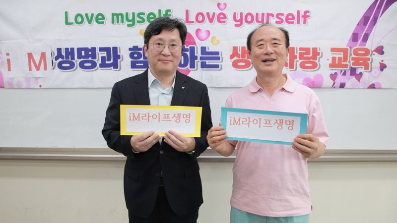 지난 27일 경기 성남시 가천대학교 가천관에서 열린 생명사랑회에서 허원 iM라이프 마케팅본부장(전무)와 양두석 생명사랑연구소장(오른쪽)이 사진을 촬영하고 있다. 사진=iM라이프 제공