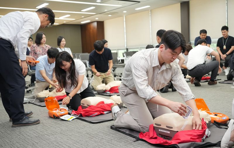 BNK경남은행 직원들이 교육용 마네킹을 이용한 심폐소생술 실습을 하고 있다. BNK경남은행 제공