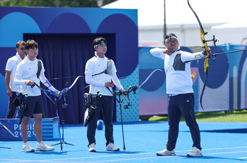 29일(현지시간) 프랑스 파리 레쟁발리드 양궁 경기장에서 열린 2024 파리올림픽 양궁 남자 단체 8강전 한국과 일본의 경기. 김우진이 활시위를 당기고 있다. 오른쪽부터 김우진, 이우석, 김제덕. / 사진 = 연합뉴스