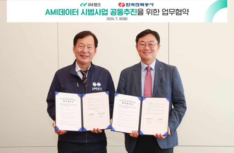 지난 30일 대구 수성구 iM뱅크 본점에서 이창우 iM뱅크 리스크관리그룹 상무와 신철호 한국전력공사 스마트미터링실 실장(오른쪽)이 사진을 찍고 있다. iM뱅크 제공