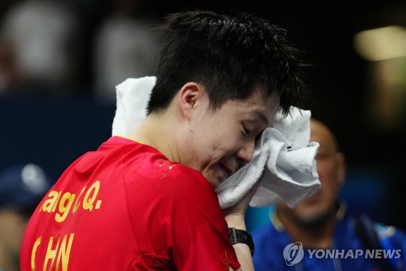 China's Wang Chuqin, right, reacts after losing by Sweden's Truls Moregrad in a men's singles round of 32 table tennis game at the 2024 Summer Olympics, Wednesday, July 31, 2024, in Paris, France. (AP Photo/Petros Giannakouris)