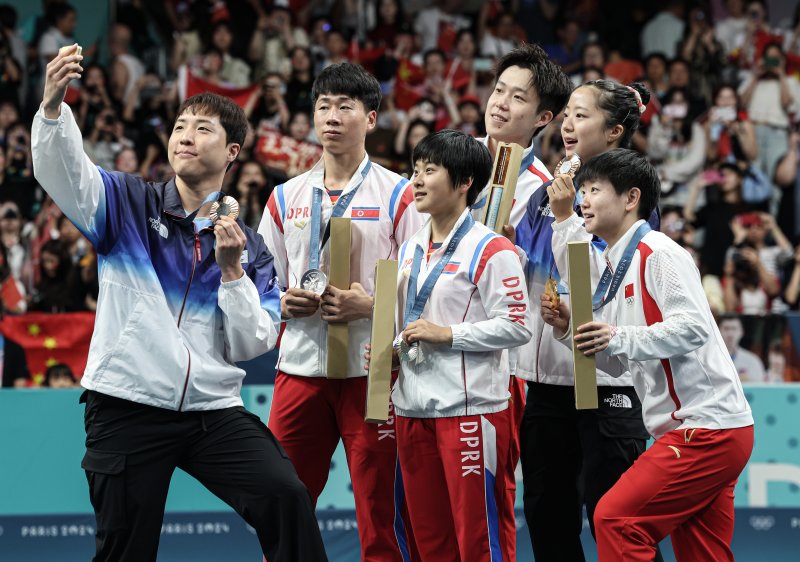 대한민국 탁구 대표팀 신유빈, 임종훈 선수가 지난달 30일(한국시간) 프랑스 파리 사우스 파리 아레나4에서 열린 '2024 파리올림픽' 탁구 혼합복식 시상식에서 금메달을 획득한 중국 왕추친, 쑨잉사와 은메달을 획득한 북한 리종식, 김금용과 함께 기념촬영을 하고 있다. /사진=뉴스1