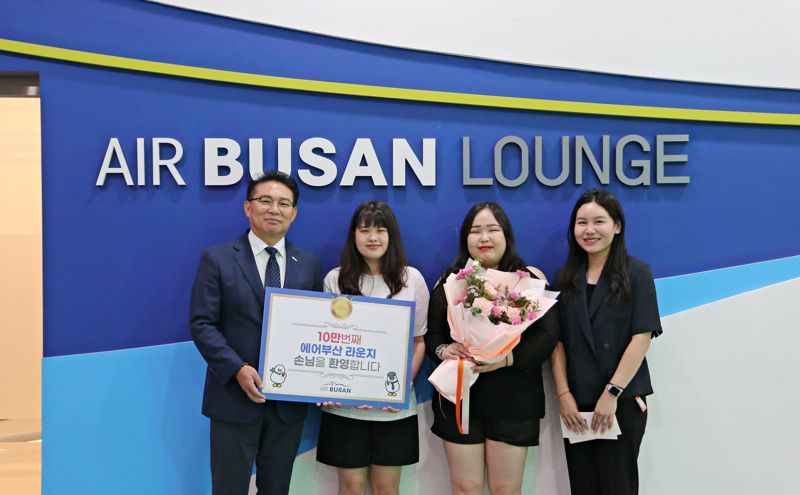 1일 김해공항 에어부산 라운지에서 에어부산 마호진 영업본부장(왼쪽 첫번째)과 관계자가 10만번째 입장객에게 국제선 왕복항공권과 기념품을 전달한 후 기념 촬영을 하고 있다. 에어부산 제공