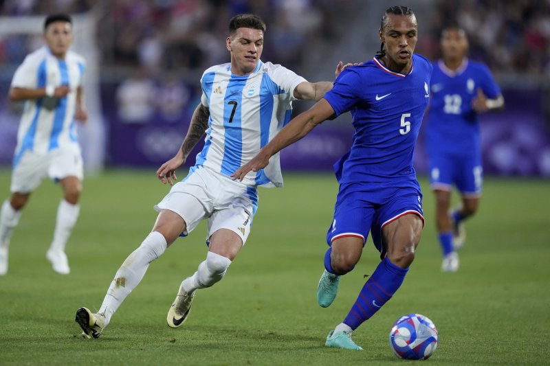 France's Kiliann Sildillia fights for the ball with Argentina's Kevin Zenon during a quarter final soccer match between France and Argentina, at Bordeaux Stadium, during the 2024 Summer Olympics, Friday, Aug. 2, 2024, in Bordeaux, France. (AP Photo/Moises Castillo)