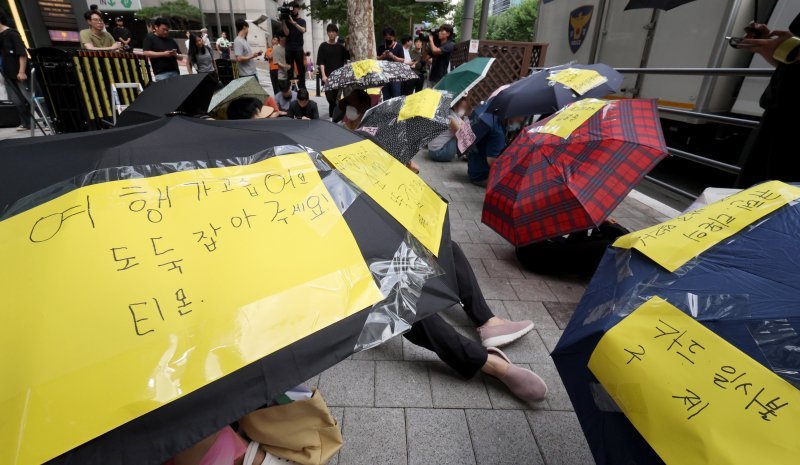 서울 강남구 큐텐 본사 앞에서 피해자들이 사태 해결을 촉구하는 문구를 붙인 우산을 쓴 채 시위하고 있다.사진=뉴스1