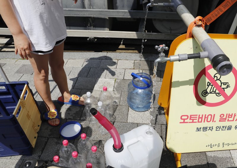 [인천=뉴시스] 김동영 기자 = 폭염주의보가 내려진 5일 오후 인천 서구 청라동 전기차 화재가 발생한 아파트 주민들이 급수차에서 물을 지원 받고 있다. 이 화재로 해당 아파트에서는 단전·단수가 5일째 이어지고 있다. 2024.08.05. dy0121@newsis.com