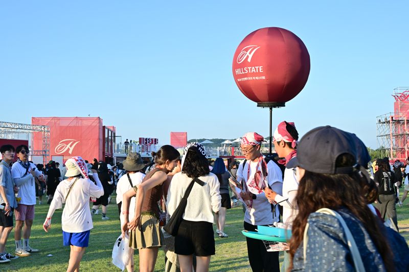 지난 2일 인천 연수구에서 열린 '2024 인천 펜타포트 락 페스티벌'에서 현대건설 직원들이 페스티벌 참가자들에게 부채를 나눠주고 있다. 현대건설 제공