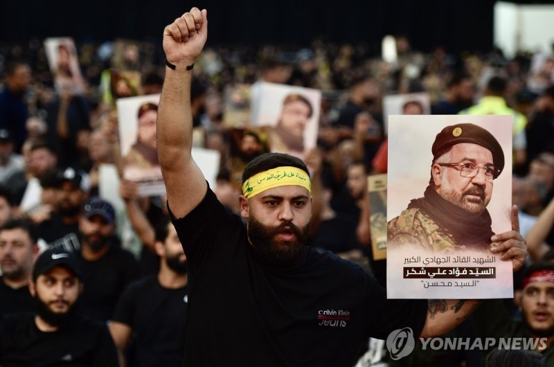 중동 '운명의 일주일'…"이스라엘, 이란 보복 막기 힘들 수도" epa11515815 Mourners hold pictures as they attend the funeral procession for late senior Hezbollah commander Fuad Shukr, killed in an Israeli strike, in Beirut, Lebanon, 01 August 2024. Hezbollah and the Israel Defense Forces (IDF) confirmed that Shukr was killed 