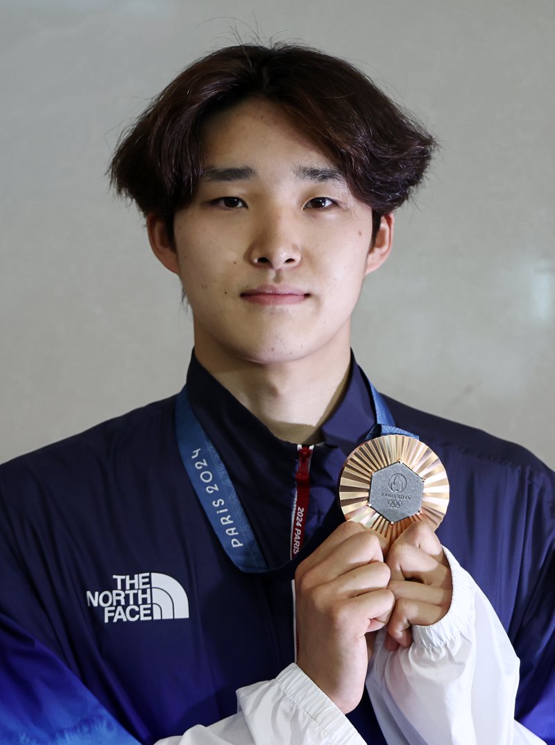 메달 들어보이는 김우민 (영종도=연합뉴스) 윤동진 기자 = 2024파리올림픽 수영 남자 400m 자유형에서 3위를 기록, 동메달을 획득한 김우민이 6일 오후 인천국제공항 2터미널 입국장을 통해 귀국 후 취재진에 메달을 들어보이고 있다. 2024.8.6 mon@yna.co.kr (끝)