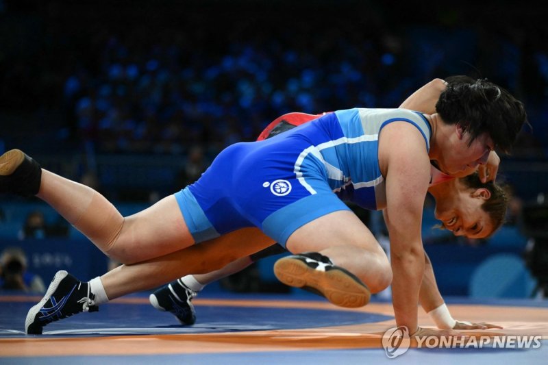 동메달 결정전에 출전한 북한의 박설금 Turkey's Buse Cavusoglu Tosun (red) wrestles North Korea's Pak Sol Gum (blue) in their women's freestle 68kg wrestling bronze medal match at the Champ-de-Mars Arena during the Paris 2024 Olympic Games, in Paris on August 6, 2024. (Photo by Luis ROBAYO / AFP)