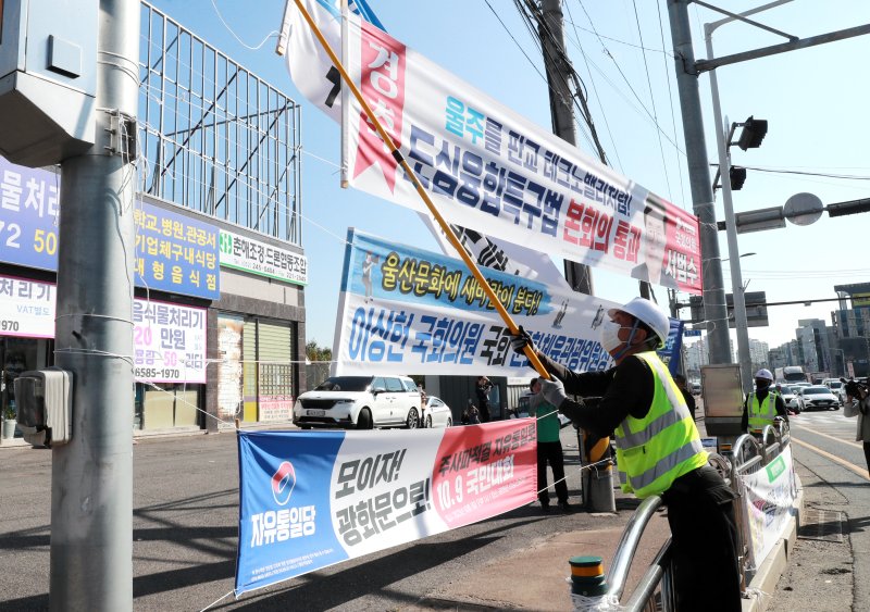 '울산시 옥외광고물 등의 관리와 옥외광고산업 진흥에 관한 조례'가 제정됐던 지난해 10월 울산시 관계자들이 울주군 범서읍 장검교차로에서 조례를 위반한 정당 현수막을 철거하고 있다. 울산시 제공