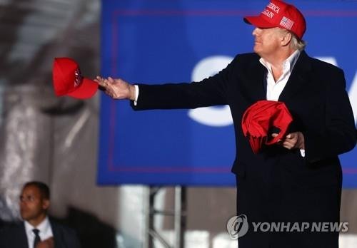 '마가 모자' 나눠주는 트럼프 전 대통령 (플로렌스=AFP 연합뉴스) 지난 2022년 1월 15일 도널드 트럼프 전 미국 대통령이 미국 애리조나주에서 열린 집회에서 연설 전 MAGA 모자를 나눠주고 있다. [재판매 및 DB 금지]