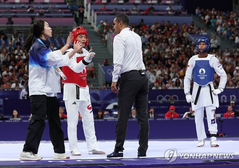 프랑스 파리 그랑팔레에서 열린 2024 파리올림픽 태권도 남자 80kg급 16강전에 출전한 한국 서건우가 칠레 호아킨 추르칠과의 2라운드에서 마지막 공격이 인정되지 않고 패배 판정을 받자 오혜리 코치와 함께 심판에 항의하고 있다.<div id='ad_body2' class='ad_center'></div> 사진=연합뉴스