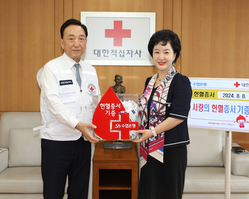 수협중앙회와 Sh수협은행은 헌혈수급 안정화를 위해 임직원들이 직접 현혈에 참여 헌혈증서를 대한적십자에 기증했다. 지난 8일 서울시 중구 대한적십자사 서울사무소에서 진행된 헌혈증서 전달식에 참석한 대한적십자사 김철수 회장(왼쪽)과 수협은행 강신숙 은행장이 기념촬영을 하고 있다. Sh수협은행 제공