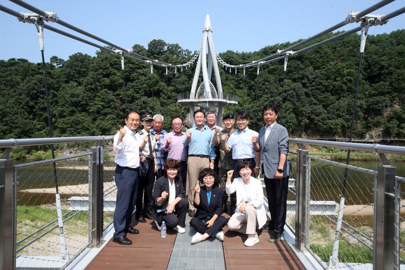 홍천군 홍천읍 송학정 인도교 개통식이 13일 현지에서 열린 가운데 신영재 홍천군수(사진 가운데)가 행사 참석자들과 기념사진을 촬영하고 있다. 홍천군 제공