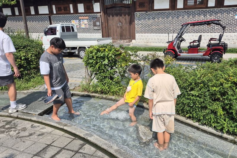 전북 전주 한옥마을 실개천에서 물놀이 하는 아이들. 전주시 제공