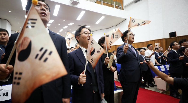 우원식 국회의장이 14일 오전 대전국립현충원에서 열린 광복 79주년 및 홍범도 장군 귀환 3주년 기념식에 참석하여 참석자들과 함께 봉오동 전투에서 사용했던 태극기를 흔들며 광복절 노래를 제창하고 있다.2024.8.14/뉴스1 ⓒ News1 김기남 기자