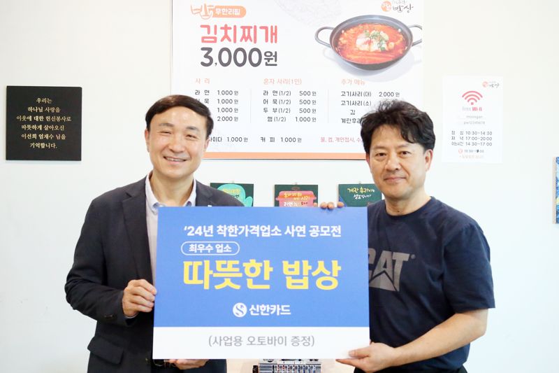 신한카드는 착한가격업소 사연 공모전을 통해 전국 9곳의 우수 업소를 선정했다고 18일 밝혔다. 16일 오후 문동권 신한카드 대표이사 사장(왼쪽)이 최우수 업소로 선정된 서울 은평구 소재 '따뜻한 밥상(연신내점)'을 방문해 사업용 오토바이 경품을 전달한 후 업주와 기념 촬영을 하고 있다. 사진=신한카드 제공