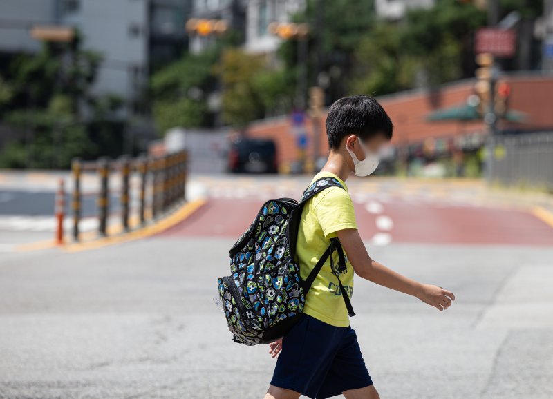 코로나19 확진자가 증가하고 있는 가운데 19일 서울의 한 초등학교에서 마스크를 착용한 학생이 하교하고 있다. 뉴스1