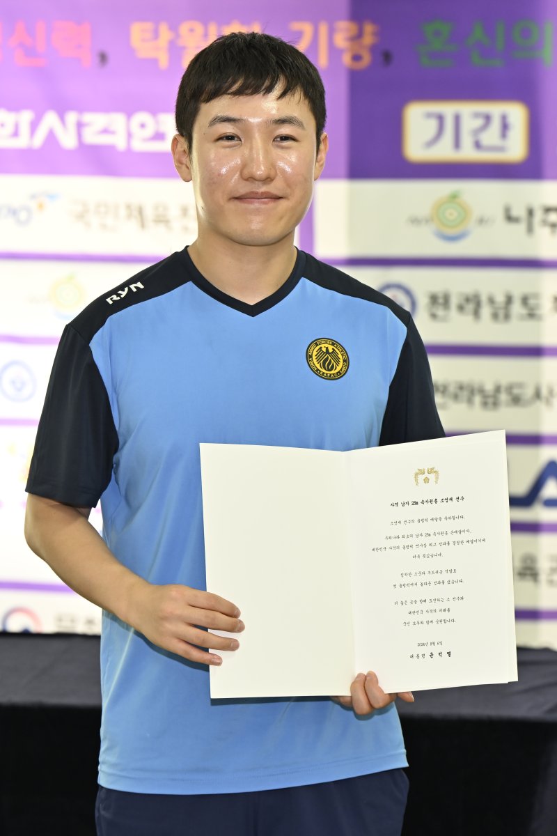 [나주=뉴시스] 박기웅 기자 = 20일 전남 나주 전남국제사격장에서 열린 '제54회 봉황기 전국사격대회'에 출전한 파리 올림픽 금메달리스트 조영재 선수가 윤석열 대통령의 축전을 들어보이고 있다. 2024.08.20. pboxer@newsis.com