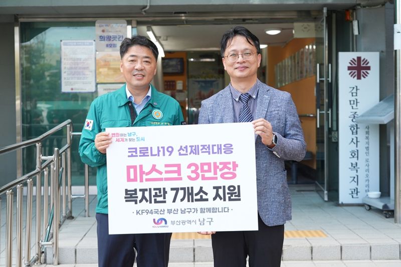 지난 22일 오은택 남구청장(왼쪽)이 감만종합사회복지관을 찾아 마스크를 전달하고 기념사진을 찍고 있다. 남구 제공