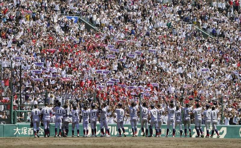 한국계 국제학교인 교토국제고 선수들이 23일 일본 효고현 니시노미야 한신고시엔구장에서 열린 전국 고교야구선수권대회(여름 고시엔) 결승전에서 간토다이이치고를 2-1로 꺾고 우승한 뒤 응원석을 찾아 인사하고 있다. / 사진 = 연합뉴스