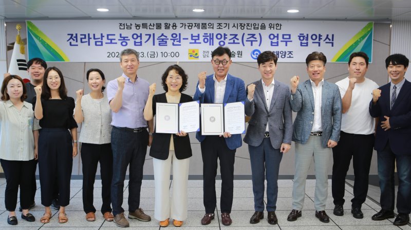 임재휘 보해양조 연구소장(오른쪽에서 다섯번째)과 김행란 전라남도 농업기술원장(오른쪽에서 여섯번째) 등 양 기관 관계자들이 업무협약을 맺은 뒤 사진촬영을 하고 있다. (보해양조 제공)/뉴스1