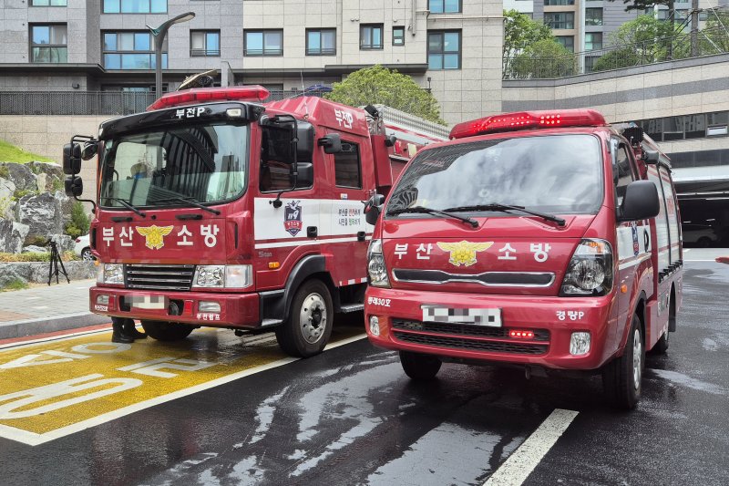 부산 소방재난본부는 27일 오전 부산 부산진구의 한 지하주차장에서 전기차 화재 대응 합동훈련을 실시했다. 부산 소방은 지게차로 화재 차량을 외부로 견인한 뒤 이동식 침수조를 설치해 차량 바퀴가 잠길 만큼 다량의 물을 짧은 시간 방수했다(맨위 사진). 이날 훈련에는 기존의 높이를 2.19m로 조정한 경형 펌프차가 투입됐다. 사진=최승한 기자, 뉴시스