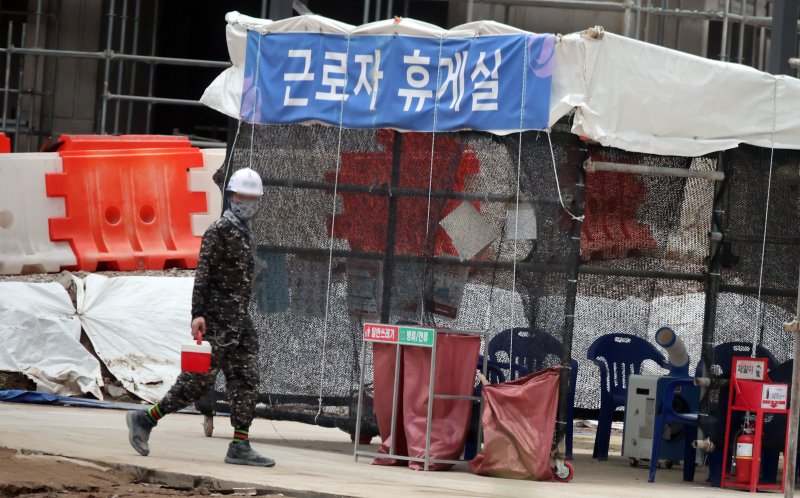 지난 8일 서울 성북구 장위4구역 주택정비사업 건설현장에서 근로자가 음료를 들고 이동하고 있다.