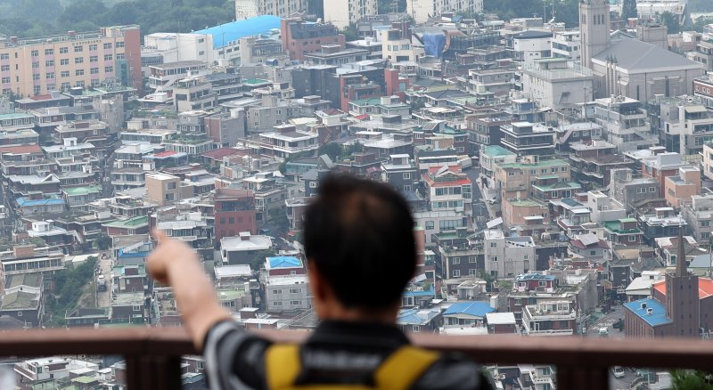 5일 오후 서울 용산구 남산에서 시민이 아파트 단지 앞으로 보이는 빌라를 바라보고 있다. 뉴시스