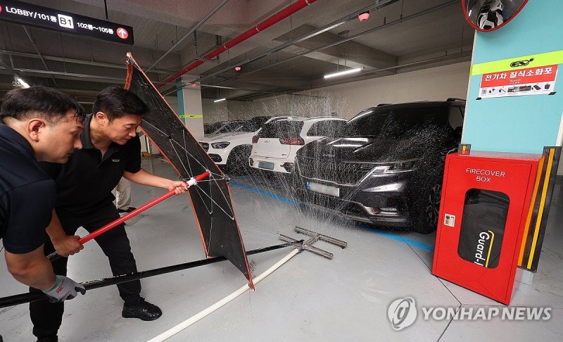 지난달 대구 동구 한 아파트 지하주차장에서 배터리 화재 대응 제품 제조 회사 가드케이 관계자들이 아파트 관리소 직원들을 대상으로 전기차 화재시 대응 방법 시연을 하고 있다. 연합뉴스