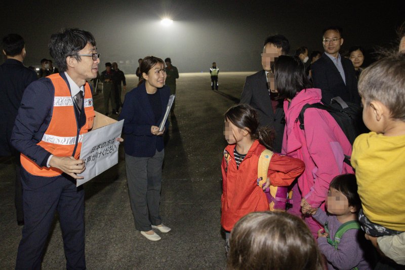 이스라엘-하마스 간 분쟁이 계속되는 가운데 지난해 10월 14일 밤 경기 성남 서울공항에서 KC-330(시그너스) 군 수송기를 통해 입국한 일본인들이 일본 대사관 직원의 수속 안내를 받고 있다. 사진=뉴시스