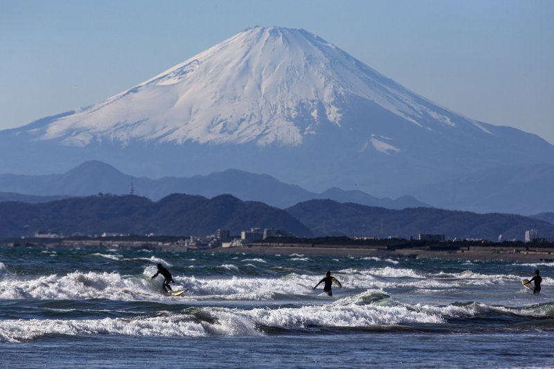 [가나가와(일본)=AP/뉴시스]일본 후지산(富士山) 대규모 분화로 수도권에 대량의 화산재가 광범위하고 긴 시간 동안 내릴 가능성에 대비해 기상청이 예보 시스템인 '광역강회예보'를 도입할 방침을 굳혔다고 5일 요미우리신문이 보도했다. 사진은 2021년 2월 19일 가나가와현 후지사와시에서 서퍼들이 후지산을 바라보며 파도를 타고 있는 모습. 2024.09.05. /사진=뉴시스