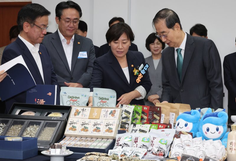 한덕수 국무총리(앞줄 오른쪽 첫번째)와 송미령 농림축산식품부 장관(앞줄 오른쪽 두번째) 및 국무위원들이 지난 3일 국무회의에 앞서 열린 쌀 가공제품(쿠키, 빵, 과자류, 음료, 한과), 과일, 전북, 해조류 등 농수산식품 소비촉진 및 추석 민생 선물세트 홍보 행사에서 시식을 하고 있다. 뉴시스