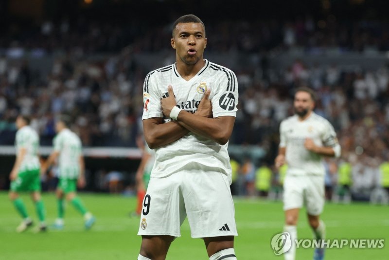 세리머니하는 음바페 TOPSHOT - Real Madrid's French forward #09 Kylian Mbappe celebrates scoring his team's second goal from the penalty spot during the Spanish league football match between Real Real Madrid CF and Real Betis at the Santiago Bernabeu stadium in Madrid on September 1, 2024. (Photo by Thomas CO