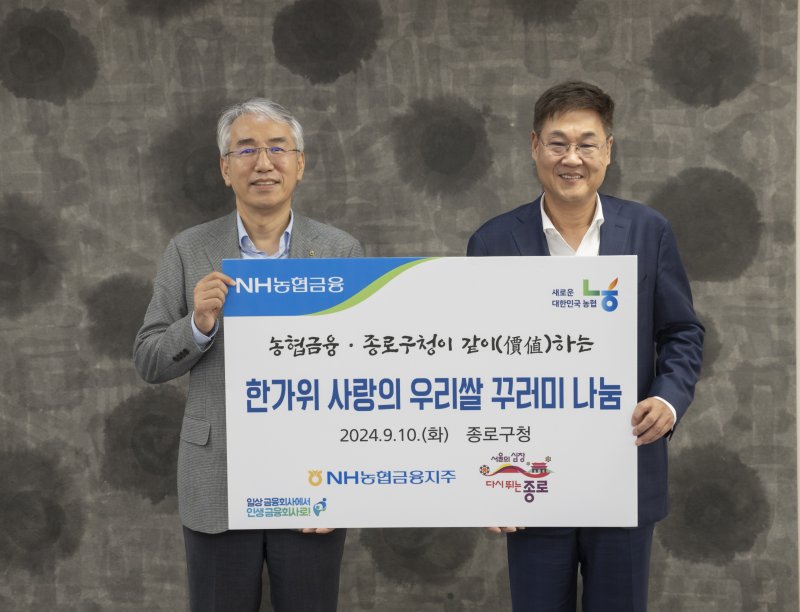 이석준 NH농협금융지주 회장(왼쪽)과 정문헌 종로구청장이 지난 10일 서울 종로구청에서 관내 소외계층에 우리쌀과 농산물 꾸러미를 전달한 뒤 기념촬영을 하고 있다. NH농협금융 제공