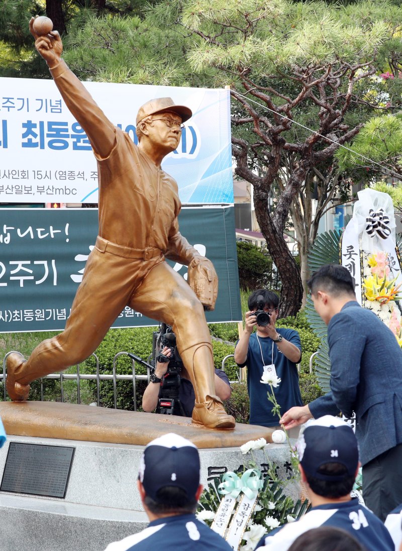 [부산=뉴시스] 하경민 기자 = 고 최동원(1958~2011) 선수의 12주기 추모행사가 열린 12일 부산 동래구 사직야구장 광장 최동원 동상 앞에서 롯데 자이언츠 관계자가 헌화하고 있다. 2023.09.12. yulnetphoto@newsis.com