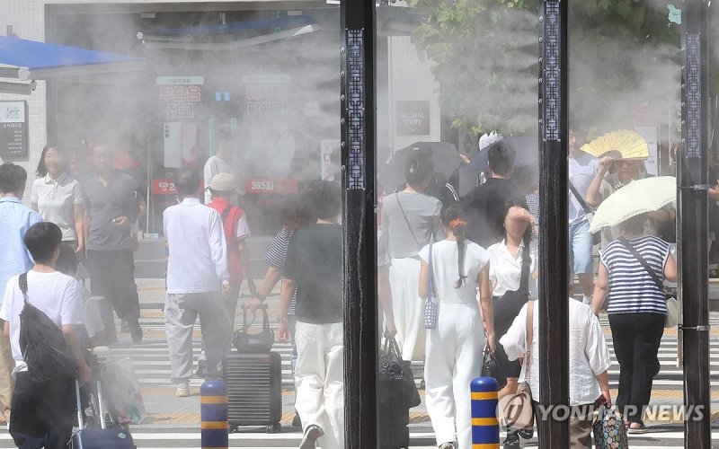 추석 연휴를 하루 앞둔 지난 13일 부산에 폭염경보가 발효된 가운데 부산역 앞 횡단보도를 지나는 귀성객 등 시민들 사이로 쿨링포그가 가동되고 있다. 연합뉴스