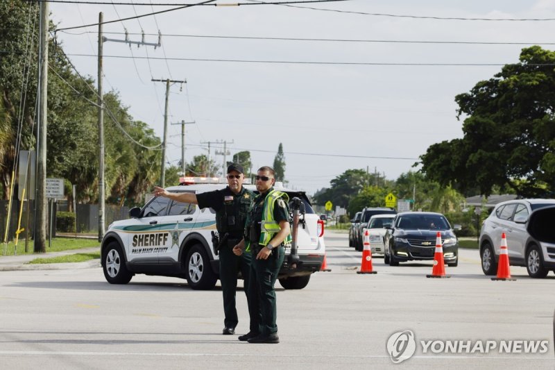 15일(현지시간) 트럼프 전 대통령 암살 미수 사건이 벌어진 플로리다 팜비치의 골프장 주변 Police officers direct traffic near Trump International Golf Club after the apparent assassination attempt of Republican presidential nominee former President Donald Trump in West Palm Beach, Fla., Sunday, Sept. 15, 2024. (AP Photo/Terry Renna)