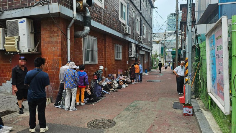 19일 낮 12시 서울 영등포구 쪽방촌에서 주민들이 33도에 육박하는 땡볕 아래 인근 의원에서 나눠주는 무료 급식을 받기 위해 기다리고 있다. 사진=노유정 기자