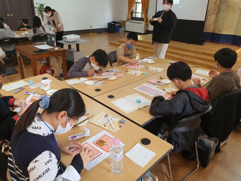 서울 덕수궁 중명전 강당에서 비밀보고서의 숨겨진 황제 어새 찾고, 숨기는 과학실험을 하는 어린이들. 국가유산청 제공