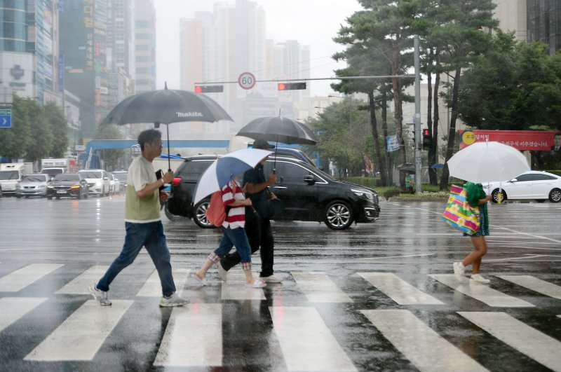 가을비가 내리고 있는 20일 광주 도심에서 시민들이 우산을 쓴 채 길을 건너고 있다. 뉴스1