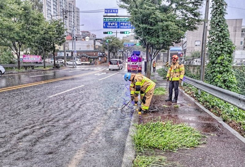 호우경보가 내려진 21일 울산 울주군 온산읍 덕산교차로에서 빗물이 역류해 소방대원이 안전 조치를 하고 있다. (울산소방본부 제공) 2024.9.21/뉴스1 ⓒ News1 조민주 기자